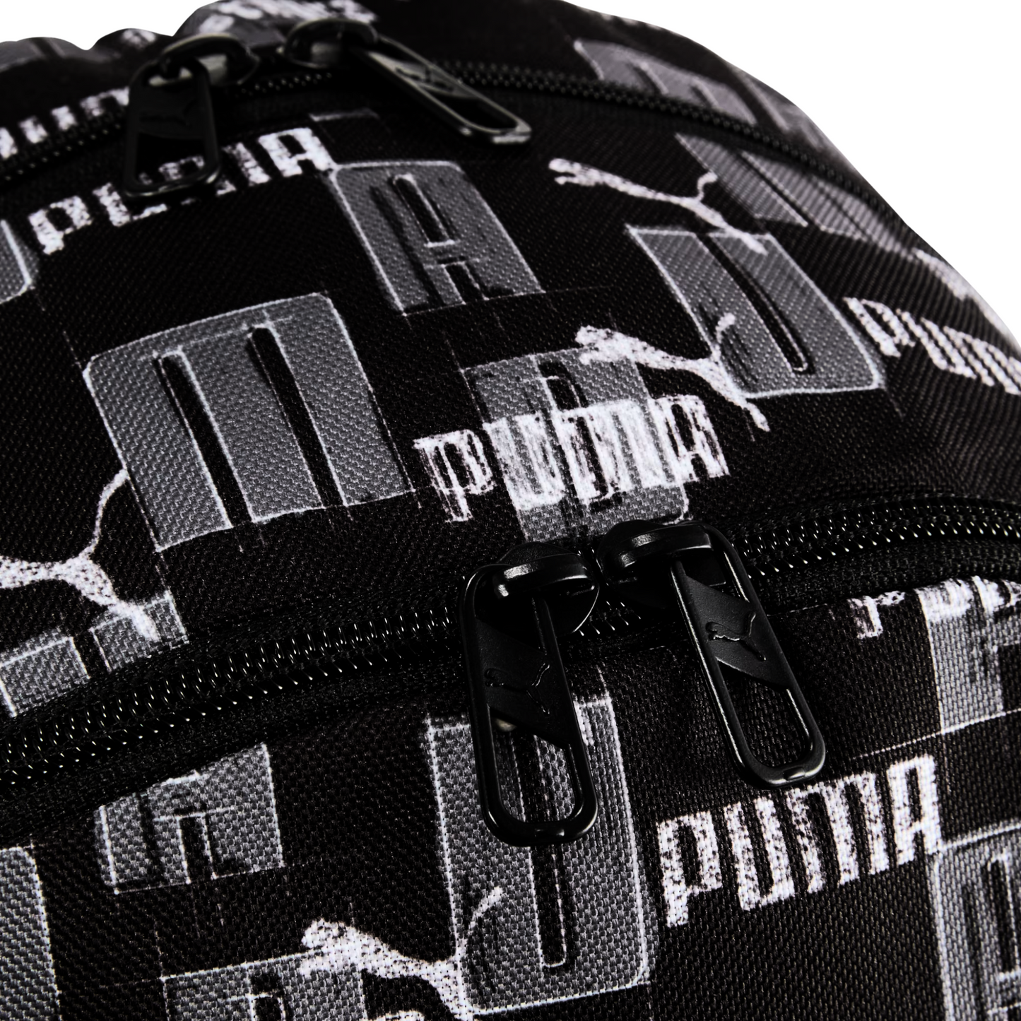 Detalle cercano del cierre y textura de la mochila Puma Academy negra con diseño de logotipos