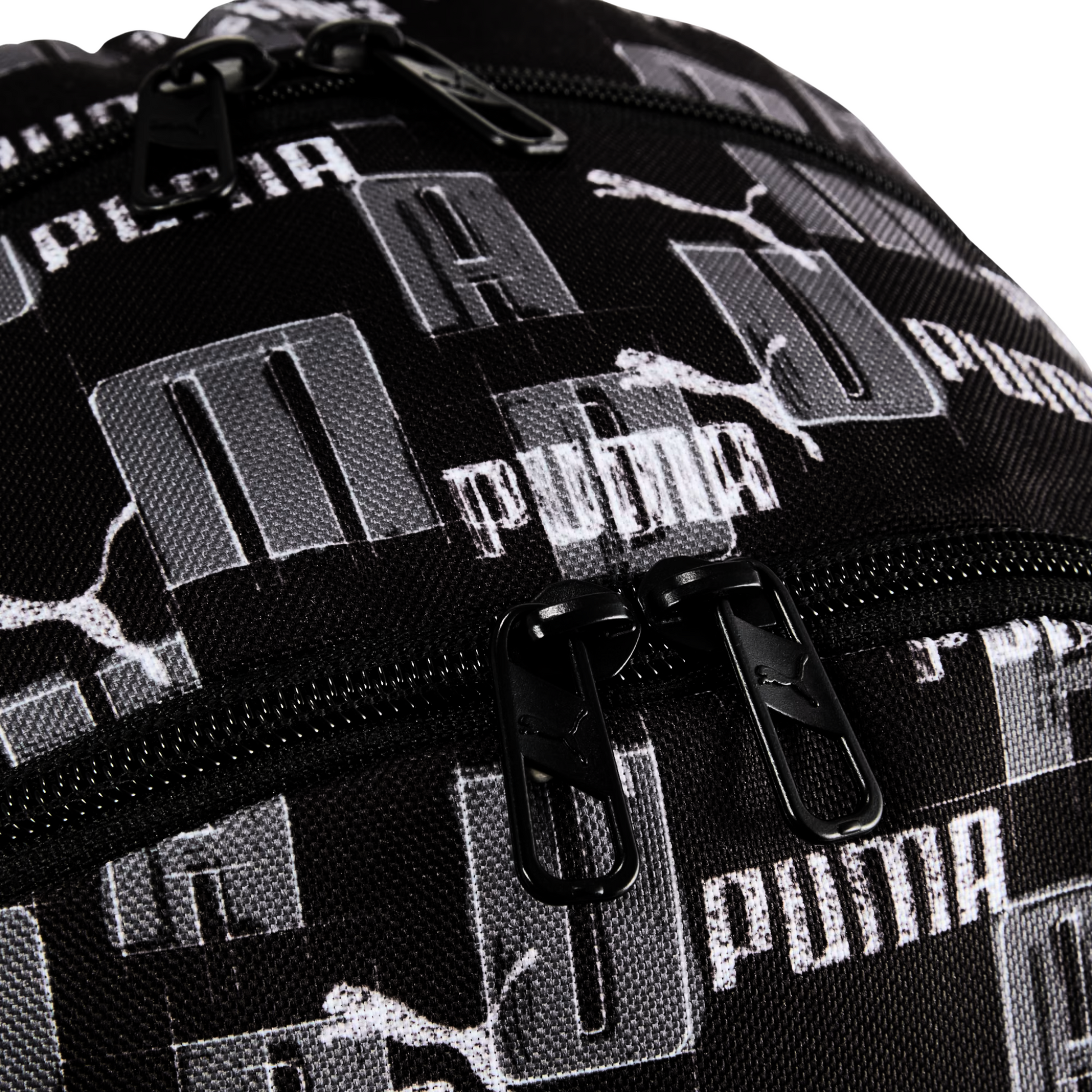 Detalle cercano del cierre y textura de la mochila Puma Academy negra con diseño de logotipos
